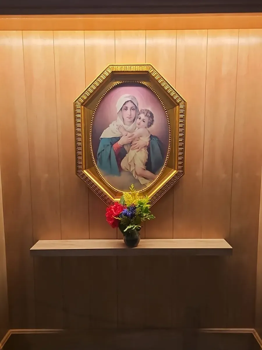 La imagen de la Mater entronizada en la Catedral de Bariloche, en su marco dorado sobre la madera